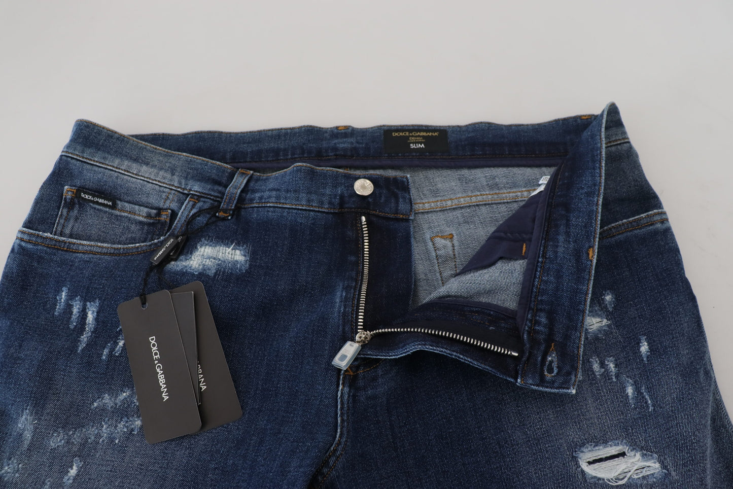 Jeans slim in denim stretch di cotone blu stracciato